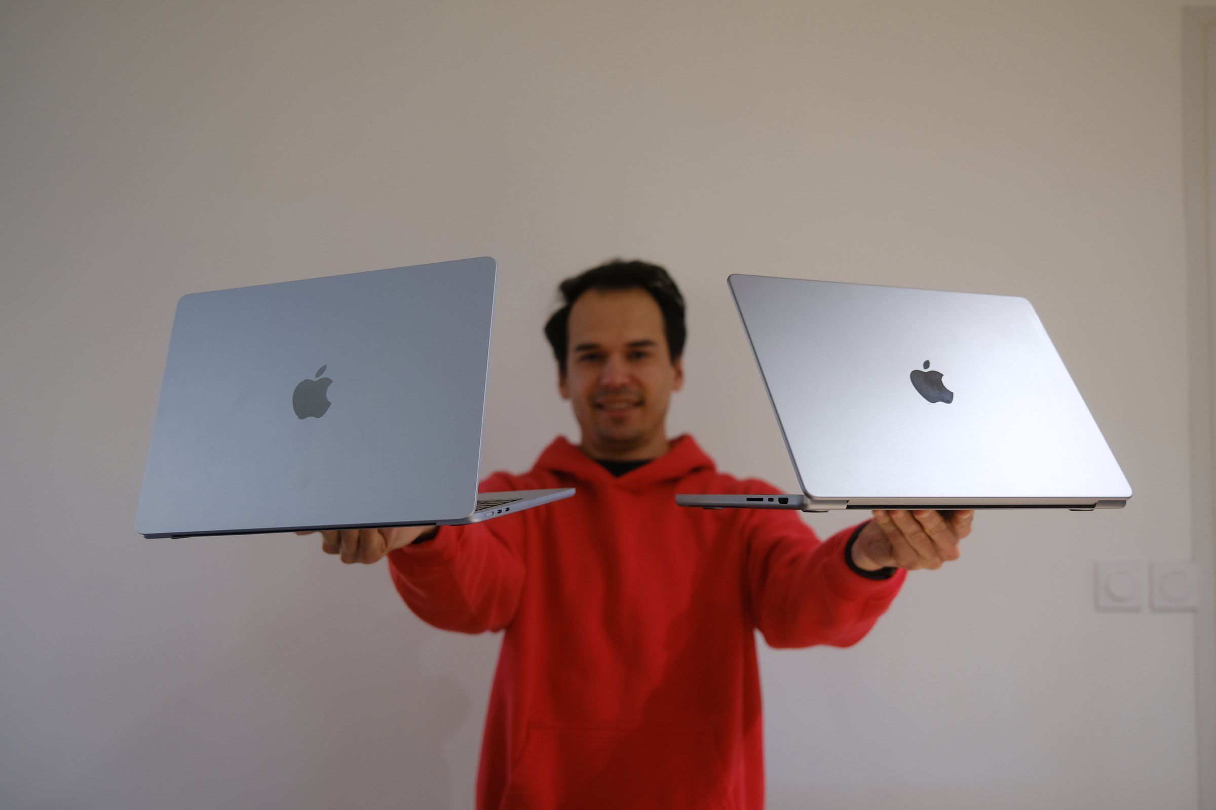 Kévin tient un MacBook Air dans une main et un MacBook Pro dans l’autre