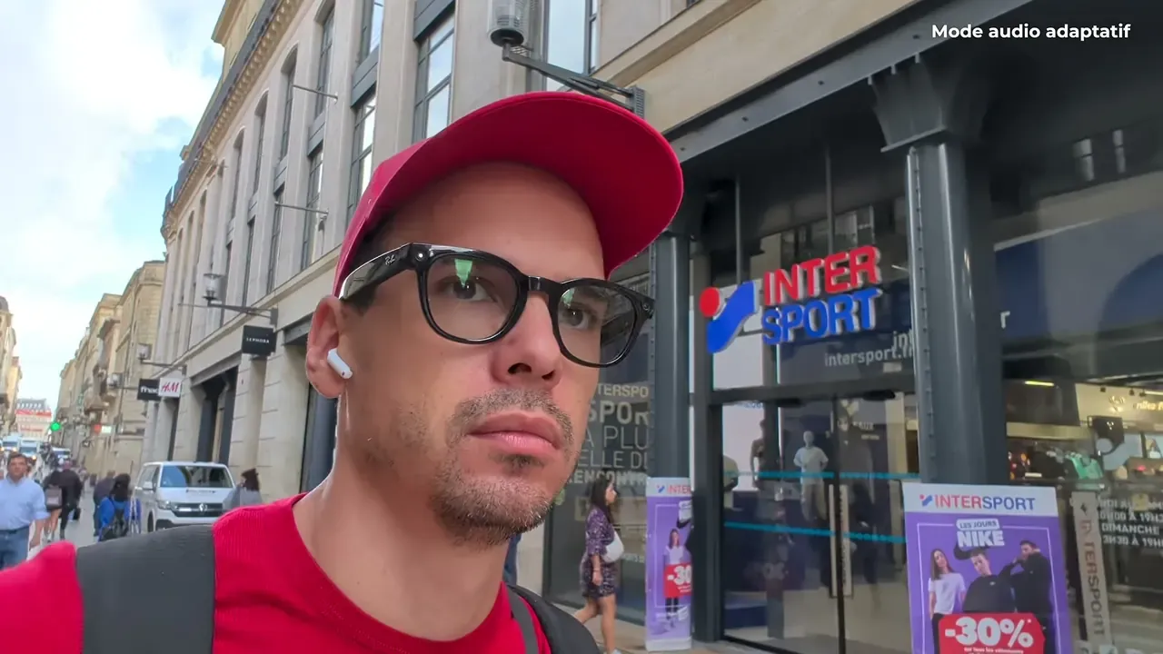 Kévin marche dans une rue commerçante avec les AirPods 5, en mode audio adaptatif