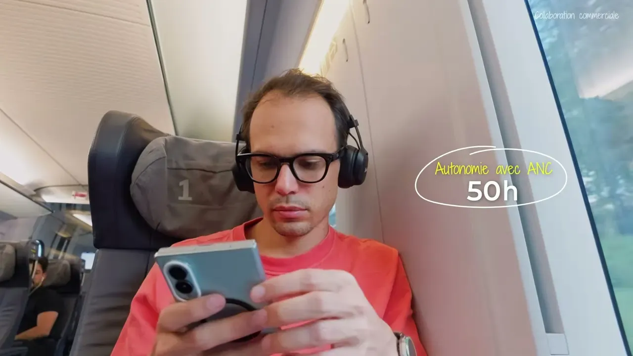 Kévin, dans un train, porte le Marshall Milton ANC en regardant son téléphone