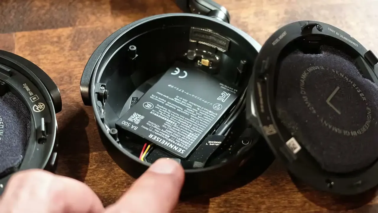 L’oreillette du Momentum 5 ouverte, le haut-parleur dévissé et la batterie visible dessous